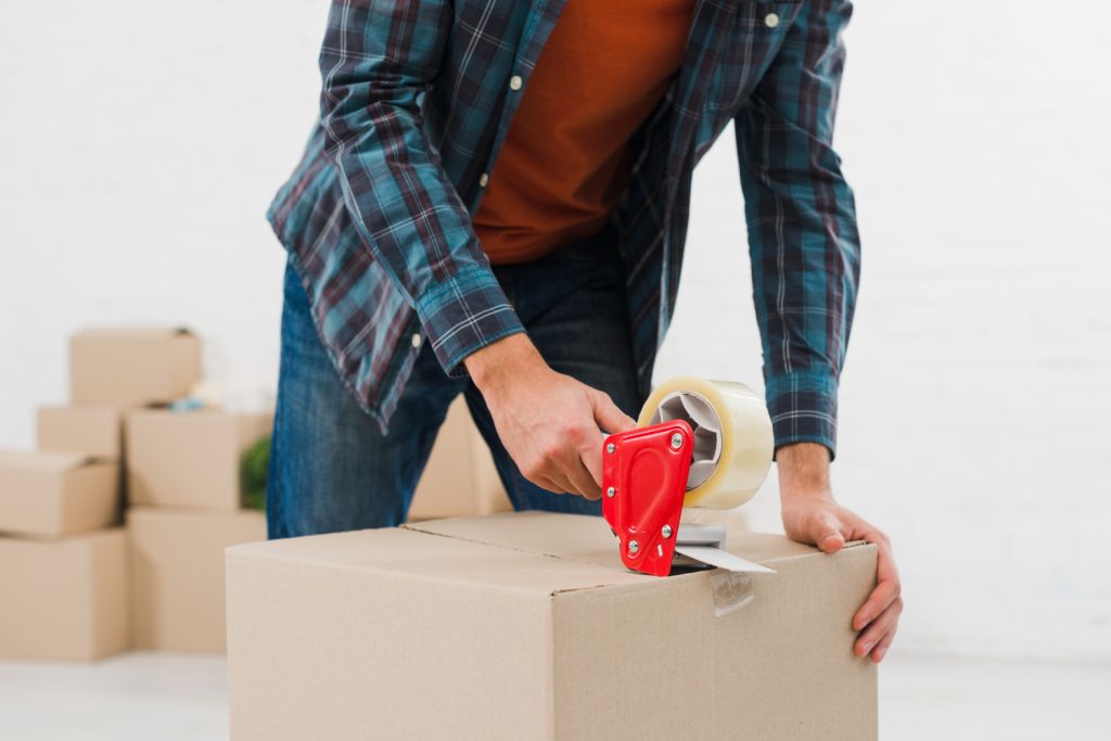 Ein Paket wird mit einem Paketroller zugeklebt